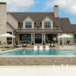 Modern farmhouse with pool, stone chimney, and outdoor seating area.