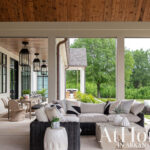 Covered patio with sectional sofa, stone coffee table, and dining set.