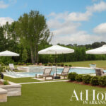 Luxury backyard with pool, hot tub, lounge chairs, and white umbrellas.