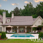 Luxury home with pool, covered patio, and manicured landscaping.