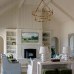 Living room with vaulted ceiling, fireplace, built-in bookshelves, and gold chandelier.