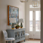 Entryway with blue cabinet, checkered chairs, and lantern pendant lights.
