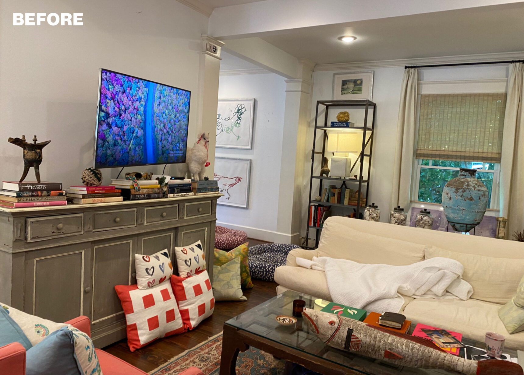 Living room with gray buffet, television, bookshelves, and sofas.