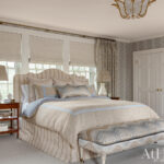 Bedroom with striped headboard, patterned bedding, and floral wallpaper
