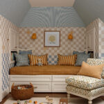 Children's room with checkered walls, built-in daybed, and floral armchair.