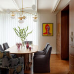 Dining room with oval wood table, upholstered chairs, and built-in wood cabinetry.