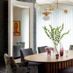 Dining room with oval wood table, patterned chairs, and modern chandelier.