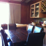 Dining room with dark wood table, black leather chairs, and built-in wine rack.
