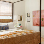 Bedroom with a woven headboard, white bedding, and a yellow floral throw blanket.