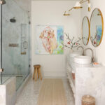 Bathroom with glass shower, marble vanity, double sinks, and dog painting