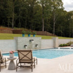 Backyard pool with waterfall feature and lounge chairs.