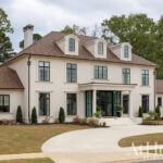 White stucco house with black-framed windows and arched dormers.