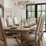 Dining room with ornate wooden table and chairs, set for a meal.