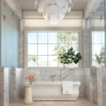 Luxury bathroom with marble tile, freestanding tub, and glass shower.