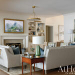 Living room with beige sofa, bookshelves, and artwork.