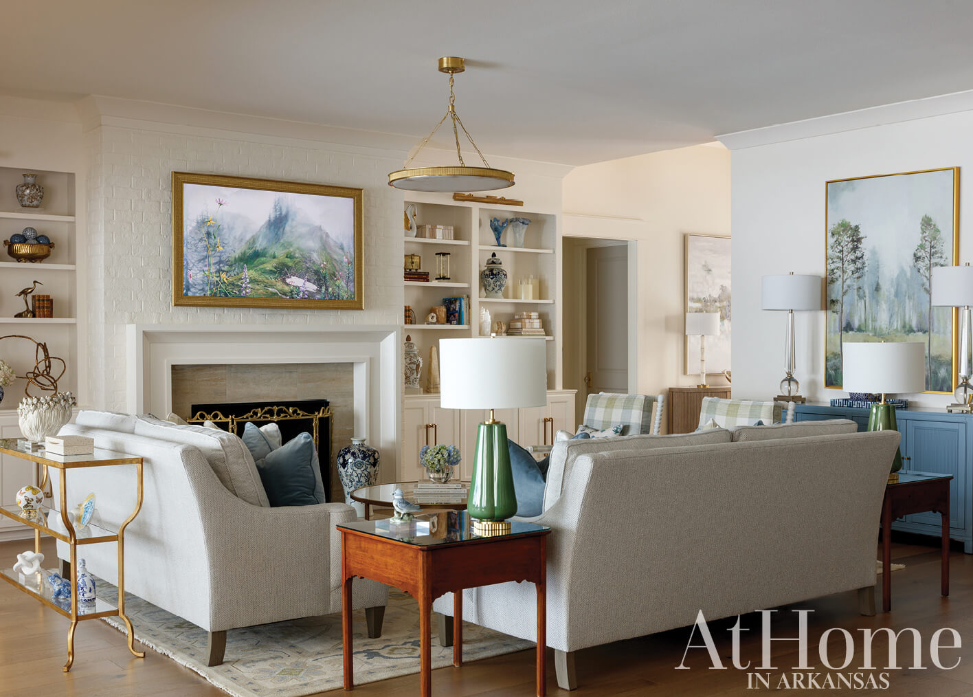 Living room with beige sofa, bookshelves, and artwork.