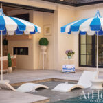 Blue and white striped umbrellas by a pool area.