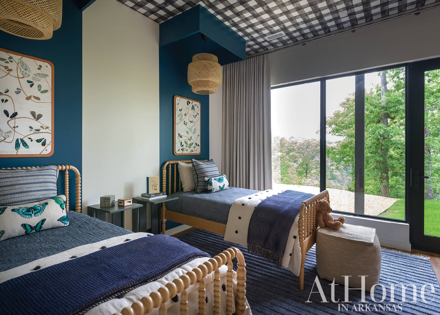 Blue bedroom with black and white checkered ceiling, twin beds, and window view.