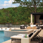Outdoor patio with pool, lounge chairs, and a lake view.