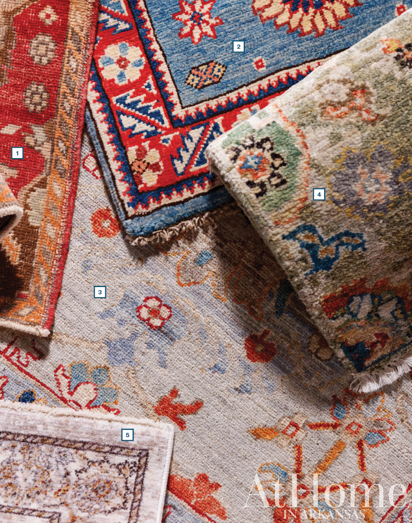 Pile of patterned rugs with red, blue, and gold designs.