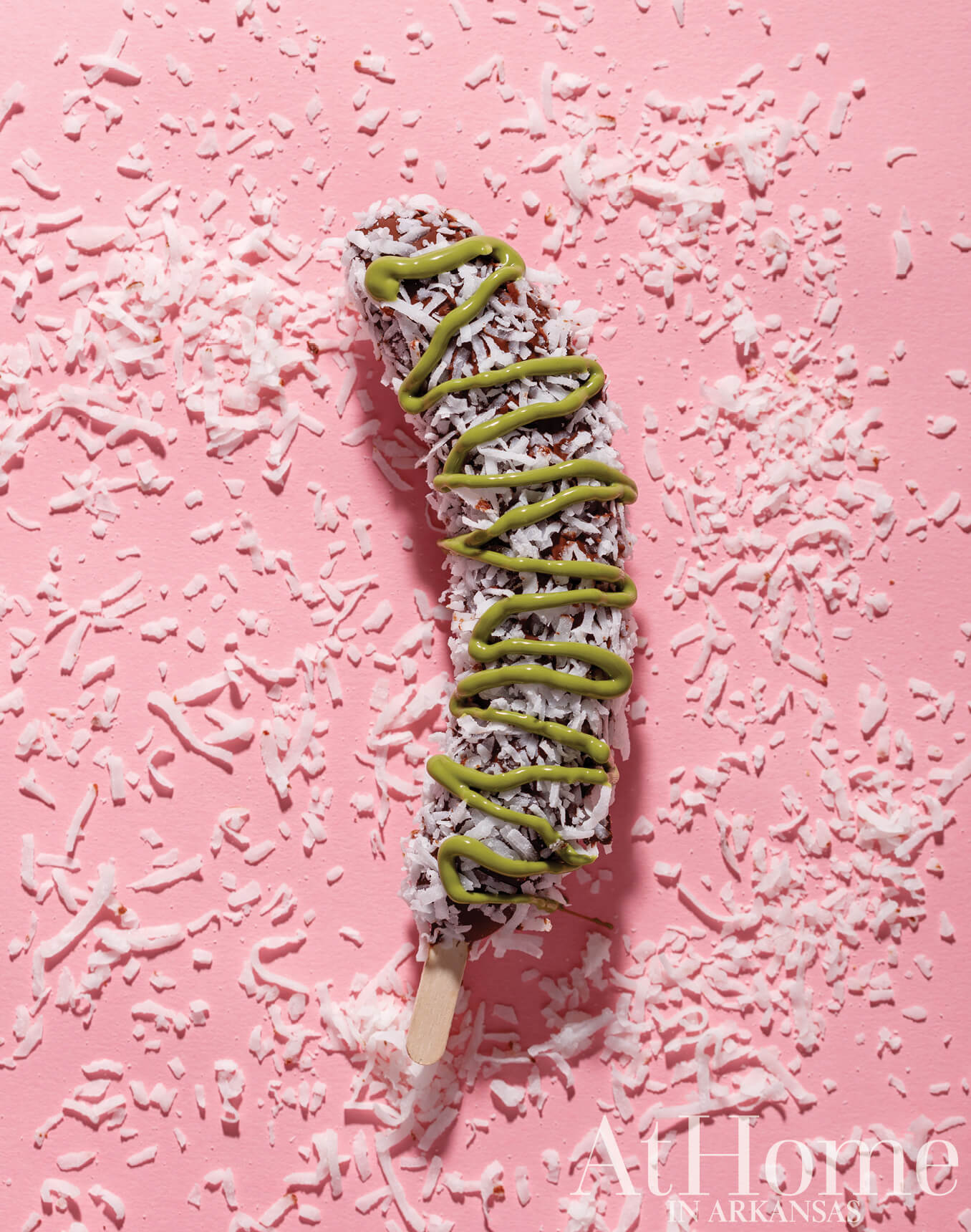 Chocolate-covered coconut popsicle on shredded coconut