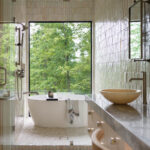 Tile-clad bathroom with large window and soaking tub.