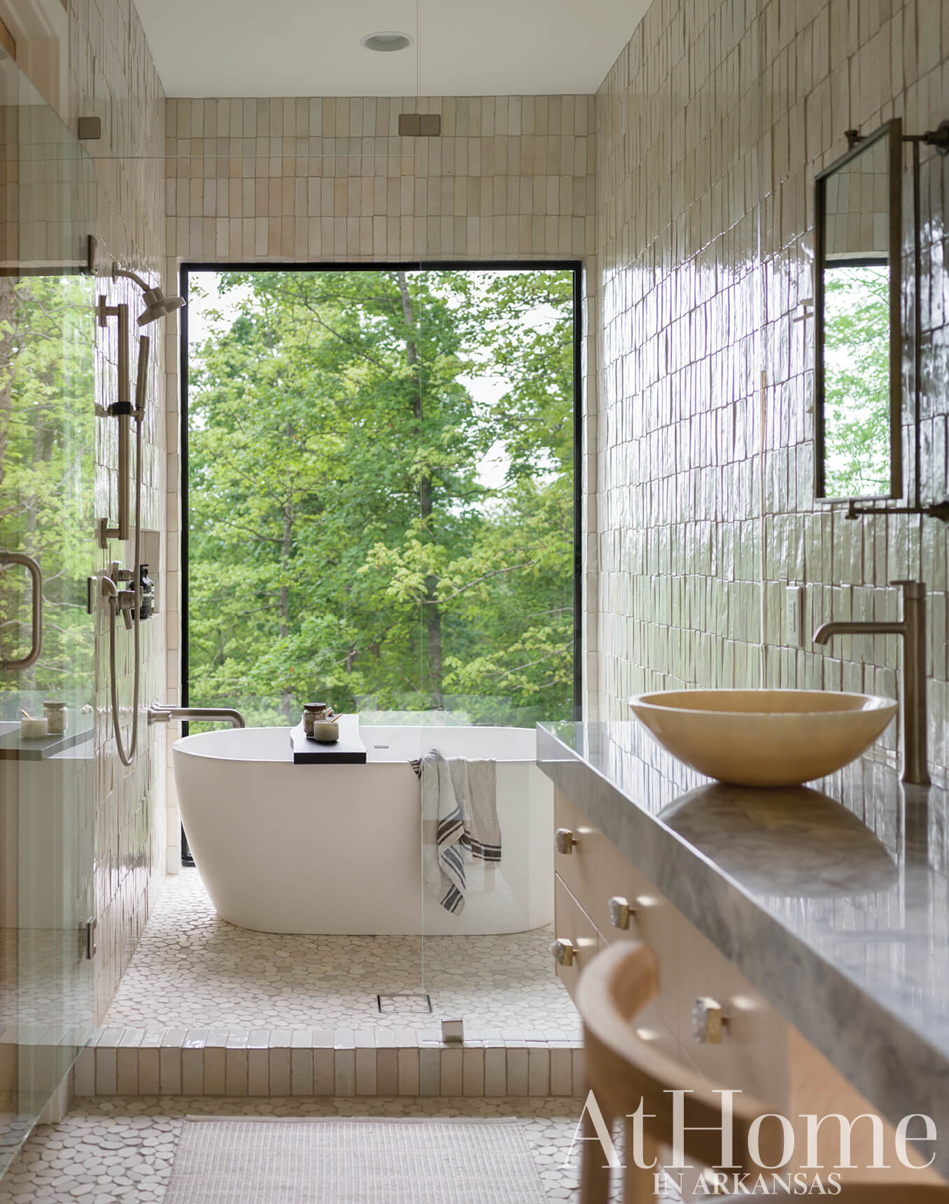 Tile-clad bathroom with large window and soaking tub.