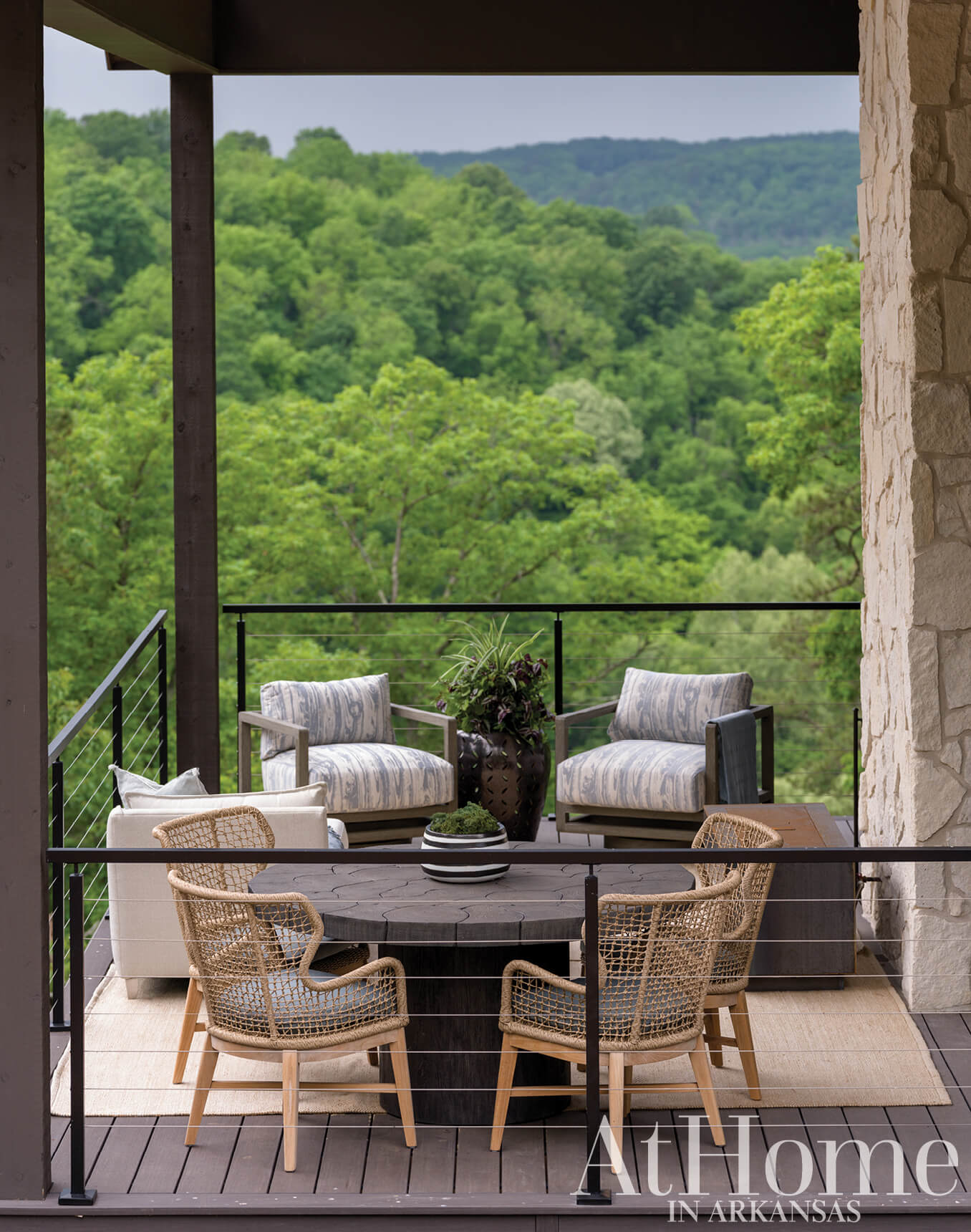 Stone patio with seating area and view of trees.