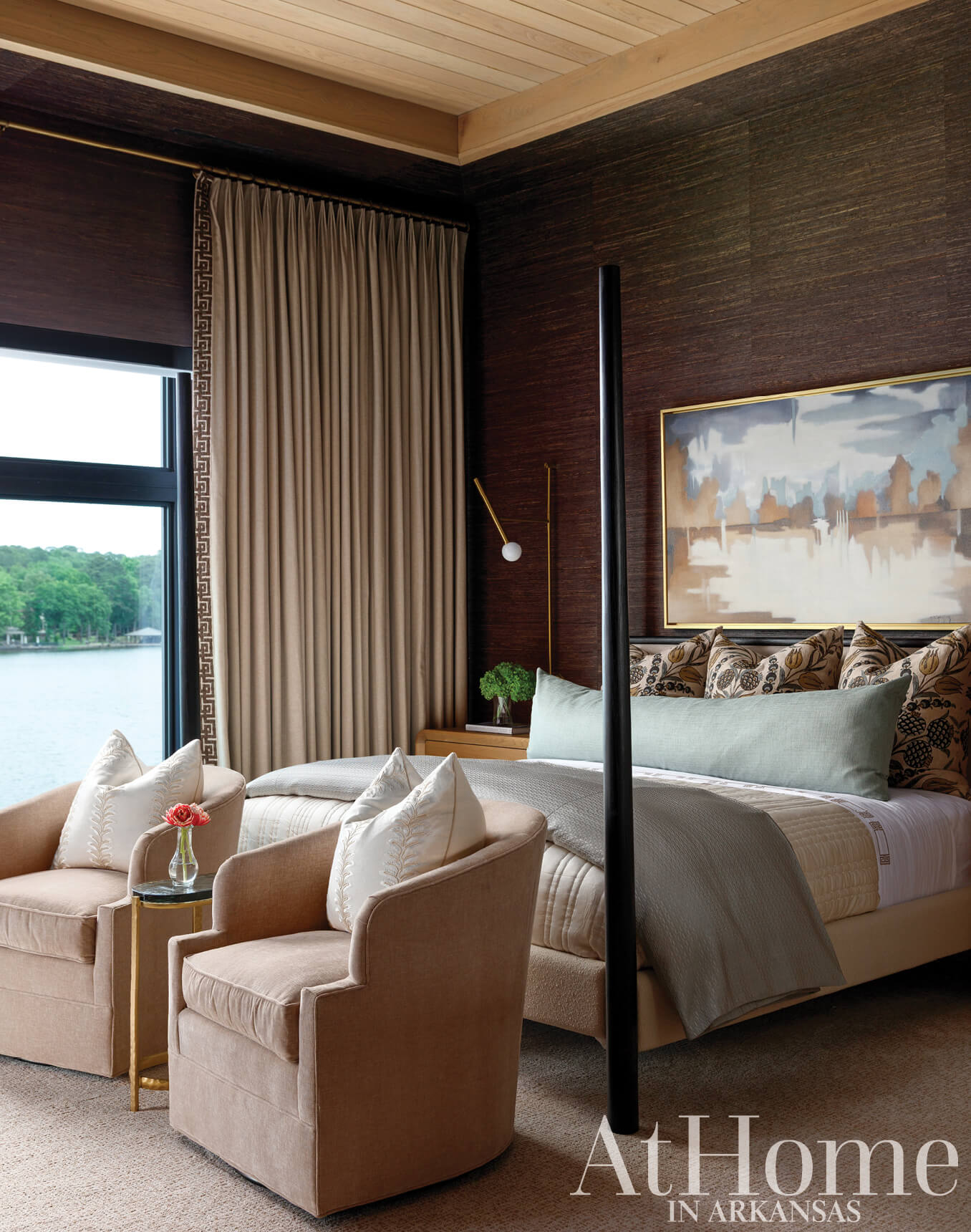 Dark wood wall paneling, beige upholstered chairs, and a four-poster bed in a bedroom.