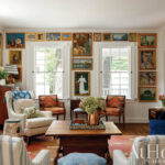 Living room with framed artwork, patterned chairs, and a wooden coffee table.