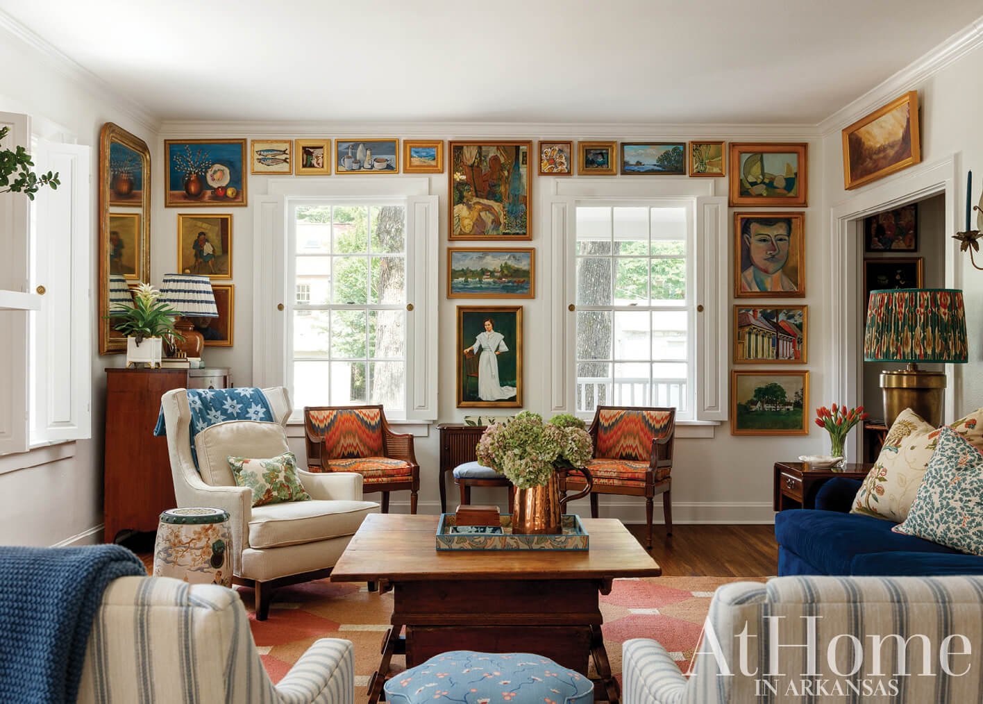 Living room with framed artwork, patterned chairs, and a wooden coffee table.