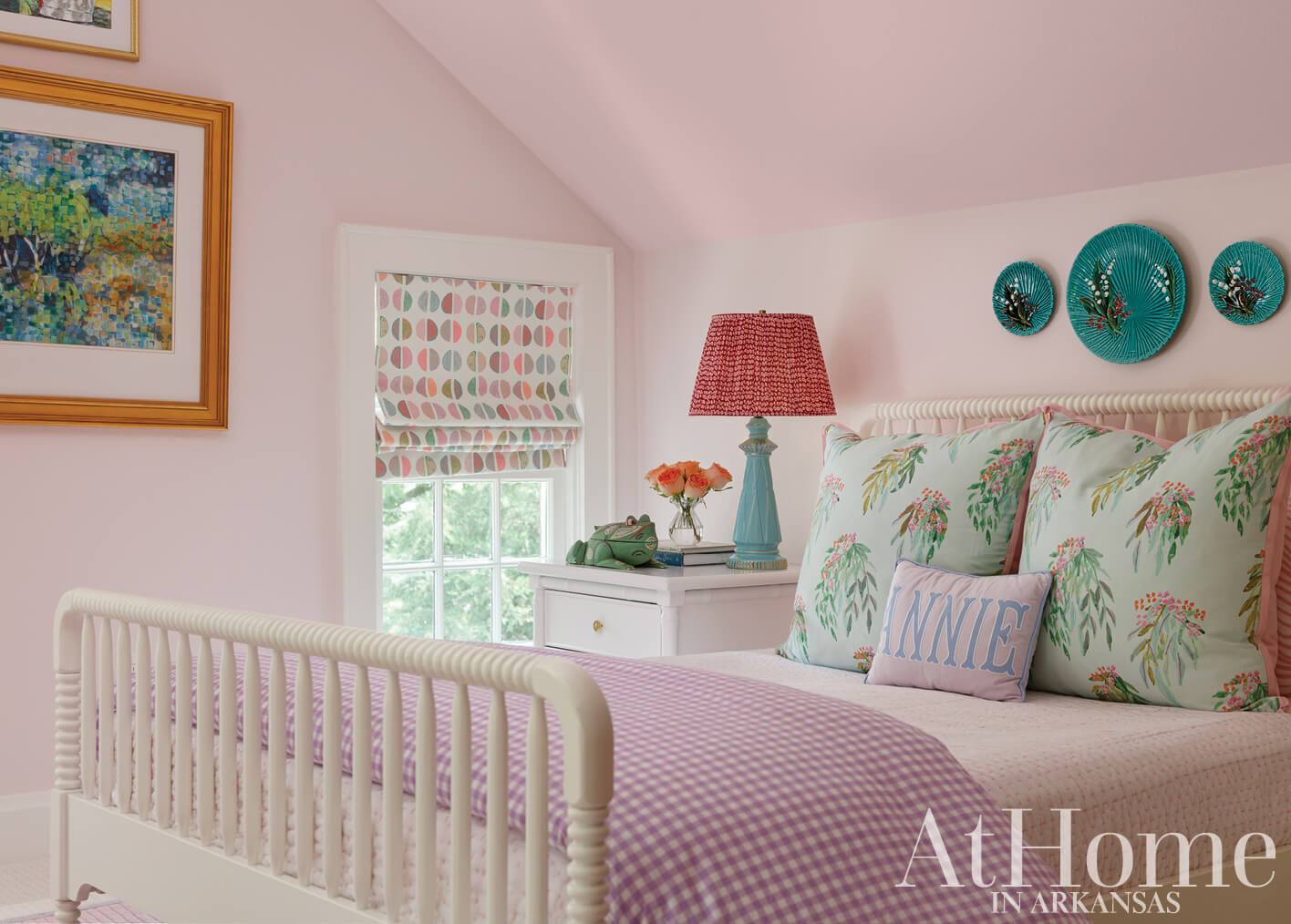 Pink bedroom with white bed, patterned drapes, and turquoise accents.