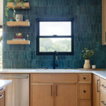 Dark teal tile backsplash with wooden cabinetry and countertop.