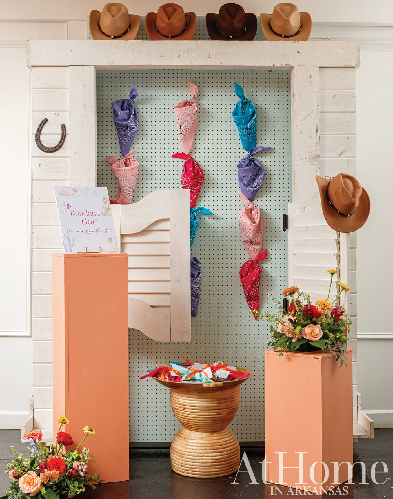 White paneling with bandanas and cowboy hats, floral centerpiece.