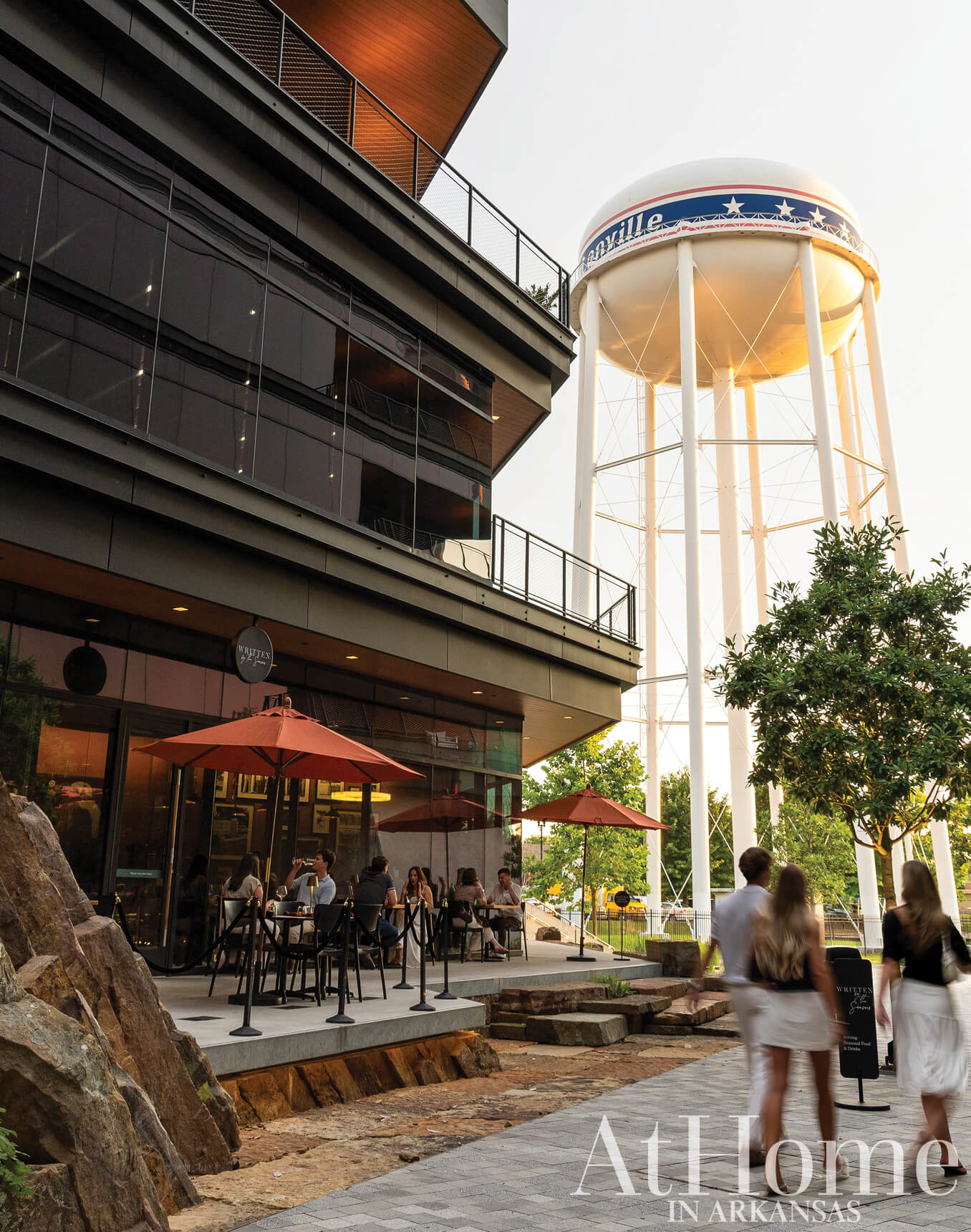 White water tower and modern building with outdoor seating area.