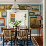 Formal dining room with a large chandelier and extensive artwork collection.