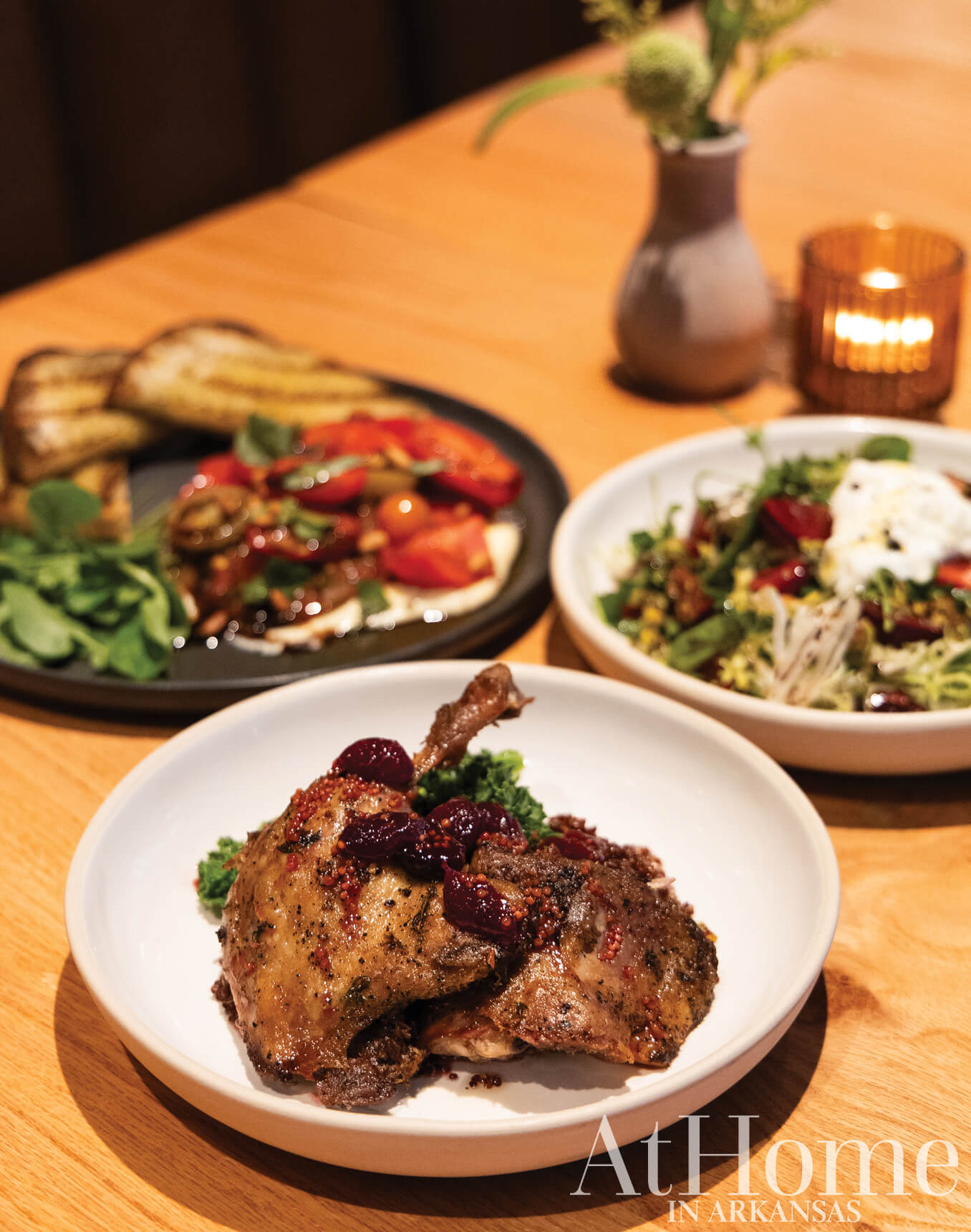 Table setting with roasted meats, salads, and bread.
