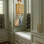 Gray built-in cabinets with a window seat and decorative artwork.