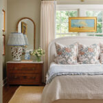 Redwood dresser with floral bedding and a patterned lamp.