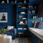 Dark blue built-in shelving unit with books and a seating area.
