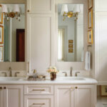 White cabinetry bathroom vanity with mirror and sconces.