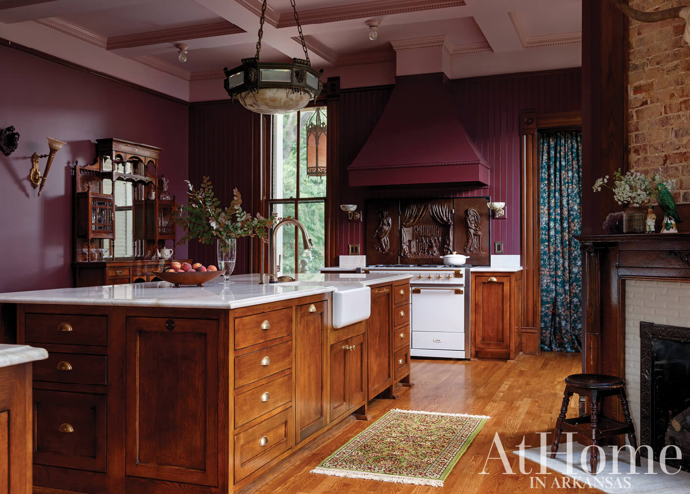 Dark wood kitchen with marble island and vintage appliances.