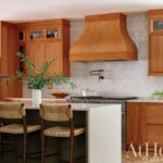 Warm wood cabinetry, tile backsplash, and a large island.
