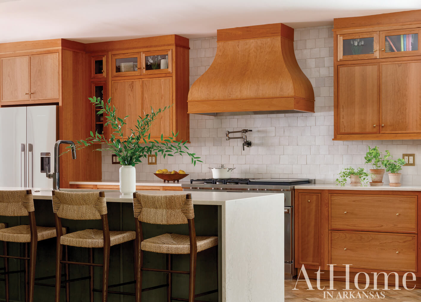 Warm wood cabinetry, tile backsplash, and a large island.