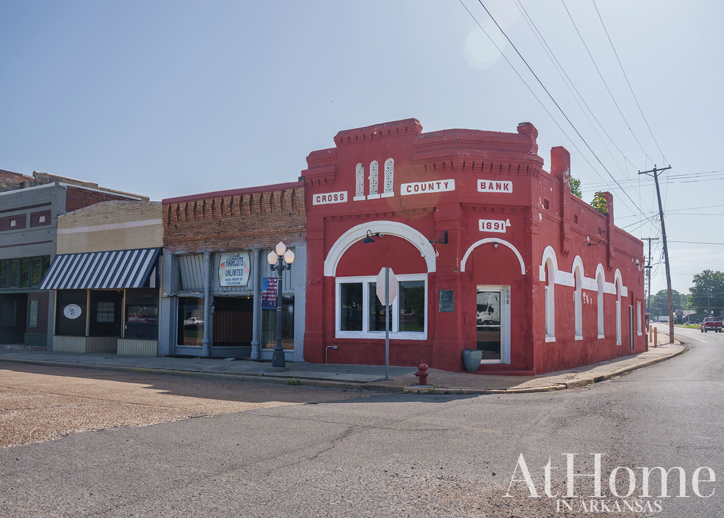 Red brick bank building with signage in a rural town.