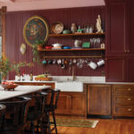 Dark wood kitchen with pink wall paneling and shelving.