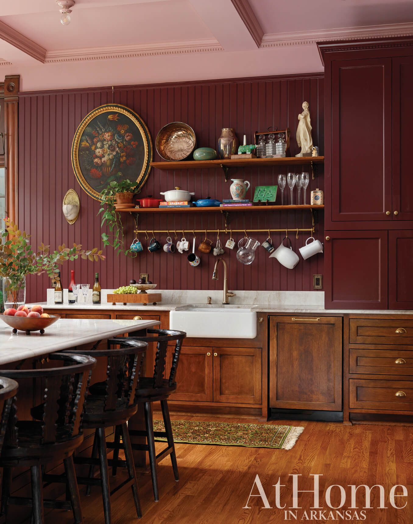 Dark wood kitchen with pink wall paneling and shelving.