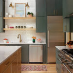 Dark green and white kitchen cabinetry with a marble countertop and stainless steel appliances.