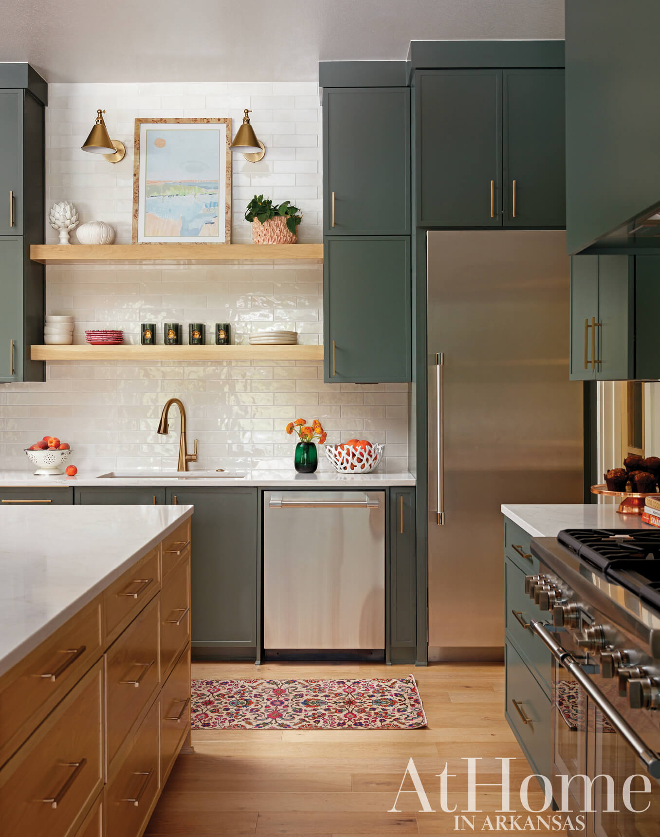 Dark green and white kitchen cabinetry with a marble countertop and stainless steel appliances.