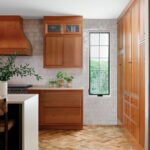 Warm wood kitchen with white subway tile and a window.